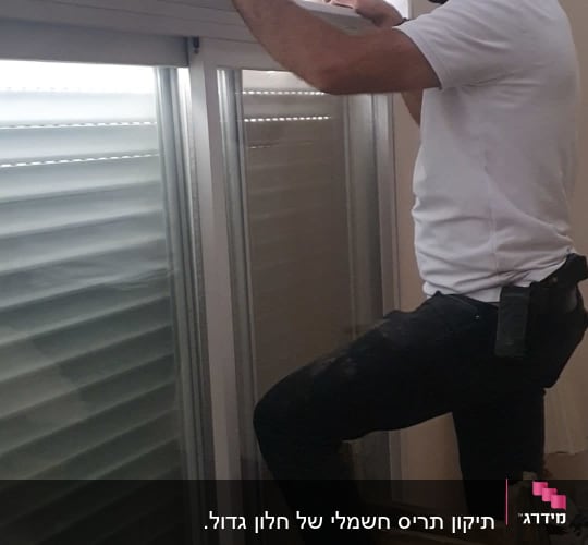 אדם מתקן תריס גלילה על סולם